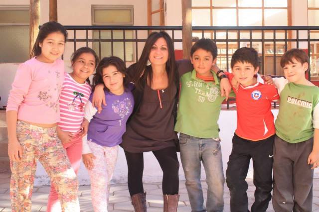 Imagen de Angélica junto a un grupo de niños peruanos, dentro de uno de sus proyectos que está llevando a cabo en Santiago de Chile